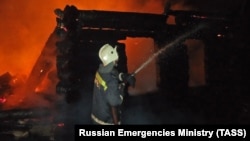 A firefighter battles the blaze in the nursing home in the village of Borovsky in Russia's Tyumen region.