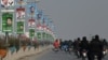 Commuters ride past election campaign posters in Rawalpindi ahead of the upcoming general elections.
