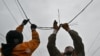 Ukrainian railroad workers repair a damaged power line after a strike in the eastern town of Druzhkivka in March.