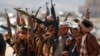 Newly recruited members of the Huthi army brandish weapons during a gathering at the end of a military training on the outskirts of Sanaa, Yemen, on January 22.