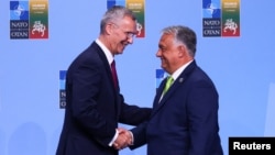 NATO Secretary-General Jens Stoltenberg (left) shakes hands with Hungarian Prime Minister Viktor Orban ahead of a NATO leaders summit in Vilnius in July 2023.
