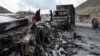 A man stands near charred truck containers torched by the armed separatist group Balochistan Liberation Army in the central Bolan district of Balochistan Province on January 30.