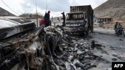 A man stands near charred truck containers torched by the armed separatist group Balochistan Liberation Army in the central Bolan district of Balochistan Province on January 30.