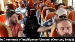 Citizens from Ukraine, Georgia, and Peru sit on a bus during their evacuation from Sudan on April 25. 