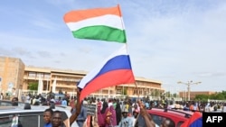 Supporters of Niger's National Council for the Safeguard of the Homeland wave Nigerien and Russian flags as they demonstrate in Niamey on August 6.