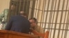 Ukrainian citizen Volodymyr Kadaria in a defendant's cage in a Bishkek courtroom on March 1.
