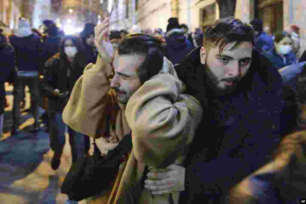 A protester wipes his eyes after tear gas was fired at protesters.&nbsp;