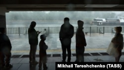 People take shelter from hurricane-force winds and pounding rain that swept Moscow on June 20.