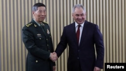 Russian Defense Minister Sergei Shoigu (right) shakes hands with his Chinese counterpart, Li Shangfu, during a meeting on the sidelines of a conference on international security in Moscow earlier this week. 