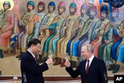 Xi Jinping (left) and Vladimir Putin share a toast on March 21 during the Chinese leader's three-day visit to Moscow.