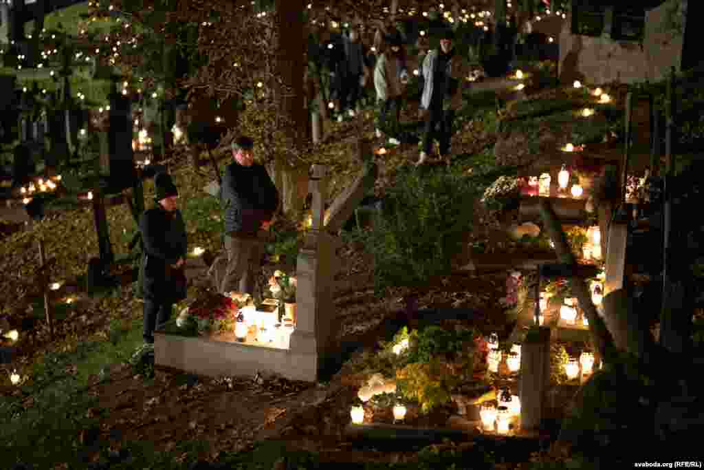 A couple pay their respects at a grave in the Rasos Cemetery.&nbsp; Around 58,000 Belarusians currently live in Lithuania, many of whom fled there after their country&#39;s disputed 2020 presidential elections and the widespread state violence that followed.&nbsp;&nbsp;