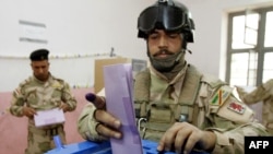 An Iraqi Army commando casts his ballot for the provincial elections at a polling station in the southern city of Basra on April 13.