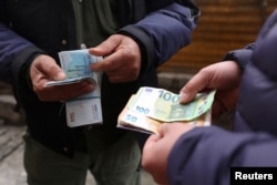 A currency dealer counts Iranian rials in Tehran on February 9.