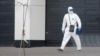 A medical specialist wearing protective gear walks outside a hospital for patients infected with the coronavirus on the outskirts of Moscow on March 23.