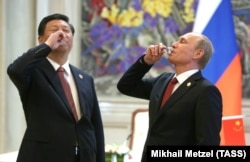 Chinese leader Xi Jinping (left) and Russian President Vladimir Putin drink in Shanghai following the signing of a gas deal in 2014.