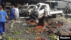 Residents inspect the site of a bomb attack in Karbala on July 3.