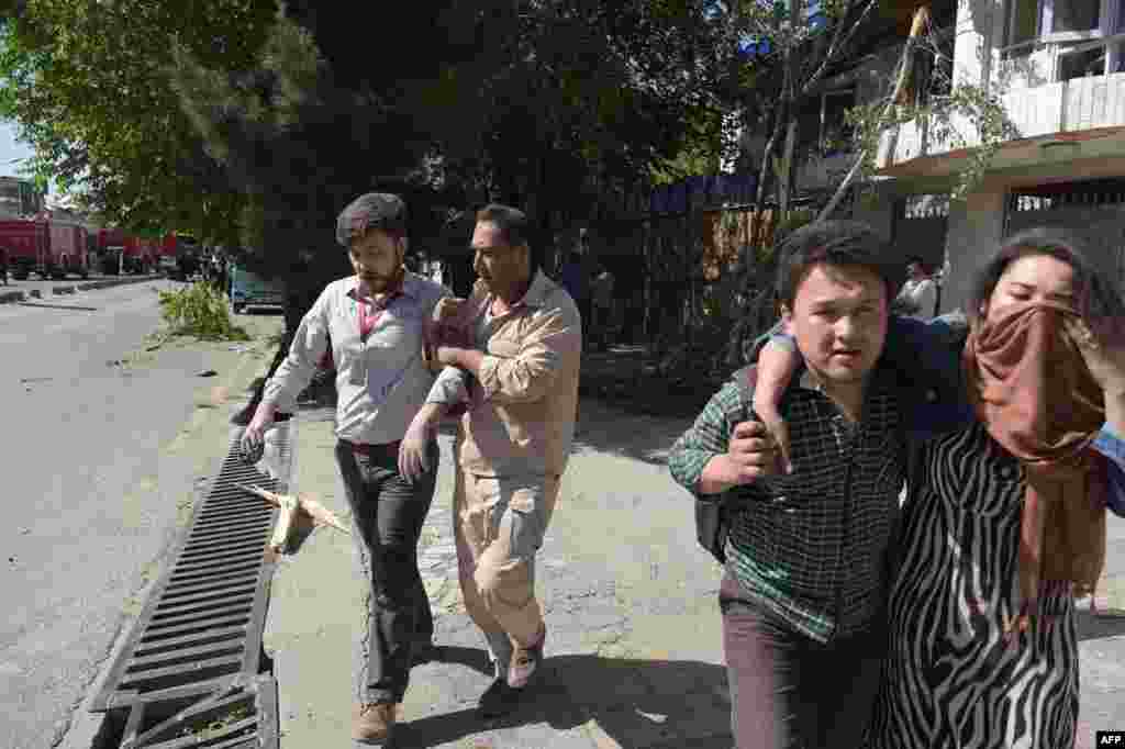 Afghan men provide assistance to the wounded.