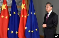 Chinese Foreign Minister Wang Yi stands next to the EU and Chinese flags as he waits for the arrival of European Council President Charles Michel in Brussels in 2019.