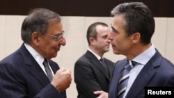 U.S. Secretary of Defense Leon Panetta (left) talks to NATO Secretary-General Anders Fogh Rasmussen during a NATO defense ministers meeting in Brussels on October 10.