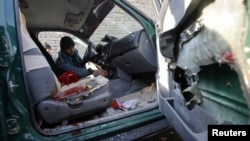 A police officer inspects the interior of the car the chief of police of Nimroz Province was in when it was hit by a roadside bomb that killed him.