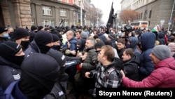 Protesters scuffle with police during a demonstration against the government's planned coronavirus restrictions in Sofia on November 25.