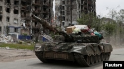 Pro-Russia troops drive a tank along a street in the town of Popasna in Ukraine's Luhansk region.