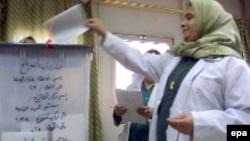 Iraq -- An Iraqi nurse casts her ballot in a box in an election station at a local hospital in Baghdad on Monday 12 Dec. 2005