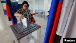 A voter casts a ballot at a polling station during local elections held by the Russian-installed authorities in Russian-controlled Donetsk on September 8.