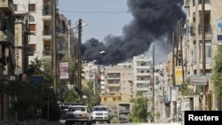 Smoke rises after a Syrian Air Force fighter jet launched missiles in the northwestern city of Aleppo on September 5.