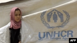 A girl looks out from a rip in a UNHCR tent at the Chukook camp for the internally displaced in northwest Baghdad. (file photo)