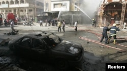 Firefighters hose down a damaged building after a fatal car bomb attack in Kirkuk.