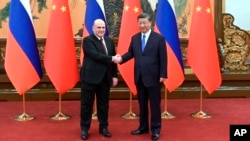 Russian Prime Minister Mikhail Mishustin (left) poses with Chinese President Xi Jinping prior to talks in Beijing on May 24.