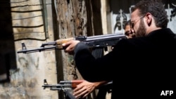 Members of the Free Syrian Army shoot at a nearby government army position in the Al-Jadeida neighbourhood of Aleppo.