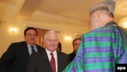 Afghan President Hamid Karzai (right) greets U.S. Defense Secretary Robert Gates (center) in Kabul.