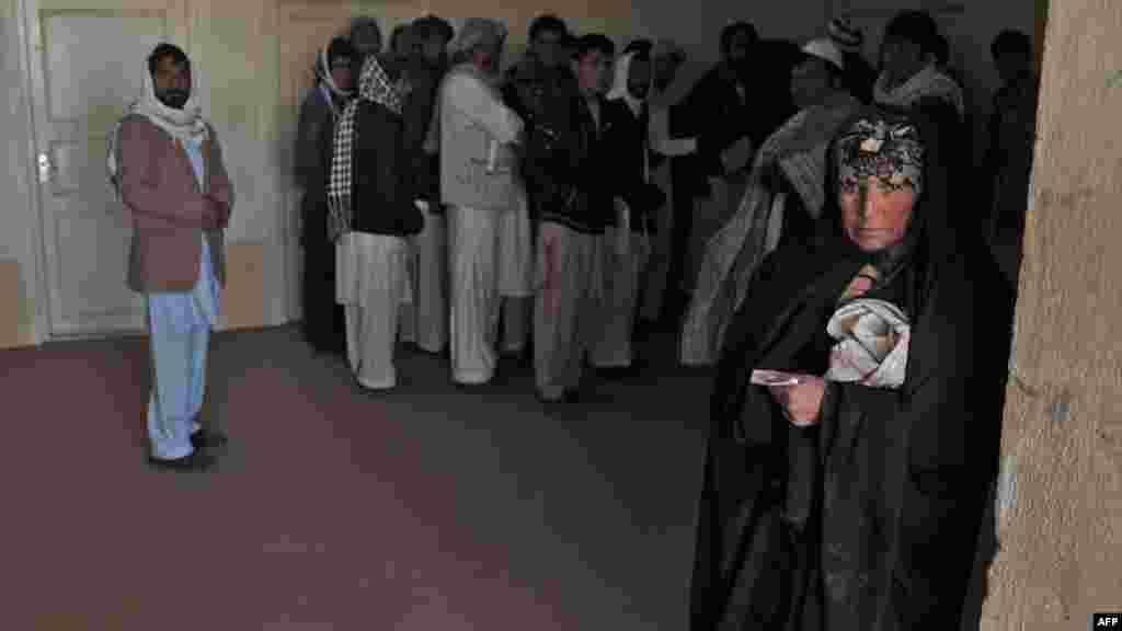 An Afghan woman who was deported from Iran to Afghanistan looks on with other returnees at the provincial refugee agency premises in Herat city in February.