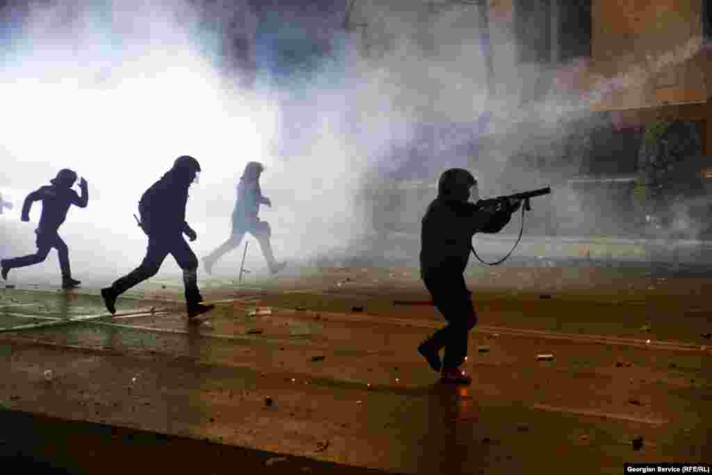 Police officers advance towards protesters on December 2. One of the officers dropped his baton amid the charge.&nbsp;