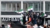 Syrians wave Syrian and German flags as they rally on December 8 in Berlin to celebrate the end of Bashar al-Assad's rule.