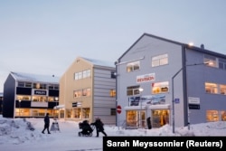 People walk past shops in Nuuk, Greenland, in February.