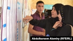 Iraqi voters look for their names in the voters' register in Basra, in southern Iraq, on April 20.