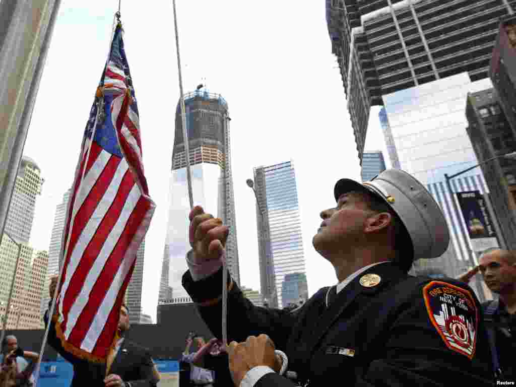 A U.S. flag is raised outside the World Trade Center construction site in New York to mark 10 years since the 9/11 attacks, when Al-Qaeda operatives used hijacked passenger planes to kill nearly 3,000 people.