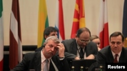 Belarus opposition leader Alyaksandr Milinkevich (L) and Polish Foreign Minister Radoslaw Sikorski share a table at a February 2 Belarus donors' conference in Warsaw.