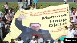 Supporters of the Peace and Democracy Party (BDP) carry an election banner of independent candidate Hatip Dicle during a protest against the election board in Diyarbakir on June 23.