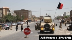 Afghan security officials and private militia members patrol in Herat on August 4.