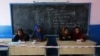 Afghan observers sit at a polling station in Kabul in the second round of the presidential election on June 14.