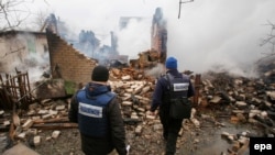 OSCE observers inspect a building that was destroyed after reported shelling in Avdiyivka in eastern Ukraine in February.