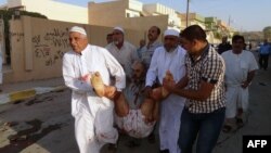 Iraqis carry a wounded man at the scene of a car bomb attack in the northern Iraqi city of Kirkuk on October 15.