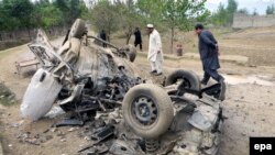 Pakistani security officials inspect the vehicle of a tribal elder who was killed when his vehicle was hit by a roadside bomb in Bajaur near the Afghan border in November 2015.