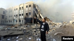 A member of Hamas security forces points to an unexploded missile (not seen) after an Israeli air strike on the building of the Hamas Interior Ministry in Gaza City.