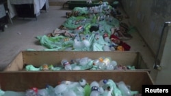 Bottles containing ice cover the bodies of people whom protesters say were killed by pro-regime forces in Deraa on June 26.