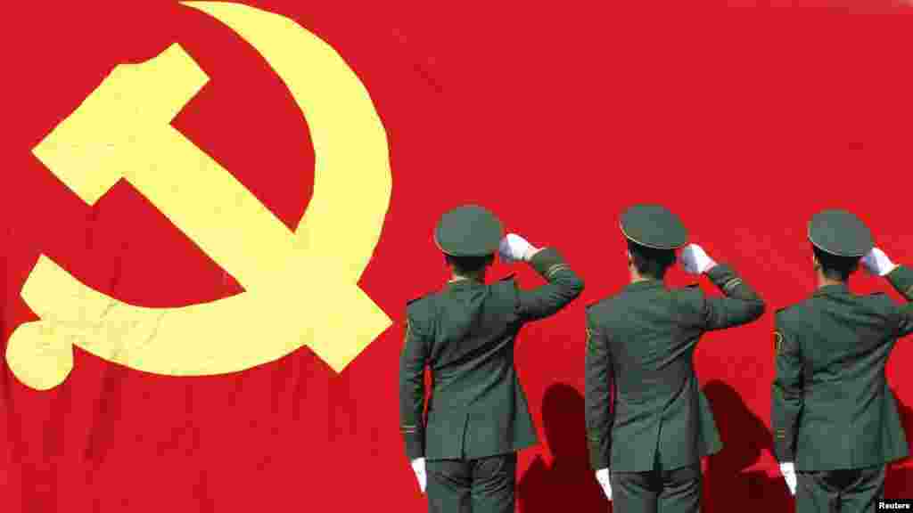 Paramilitary policemen hold their fists in front of a flag of the Communist Party as they attend an oath-taking rally to ensure the safety of the 18th National Congress of the Communist Party, at a military base in Hangzhou.